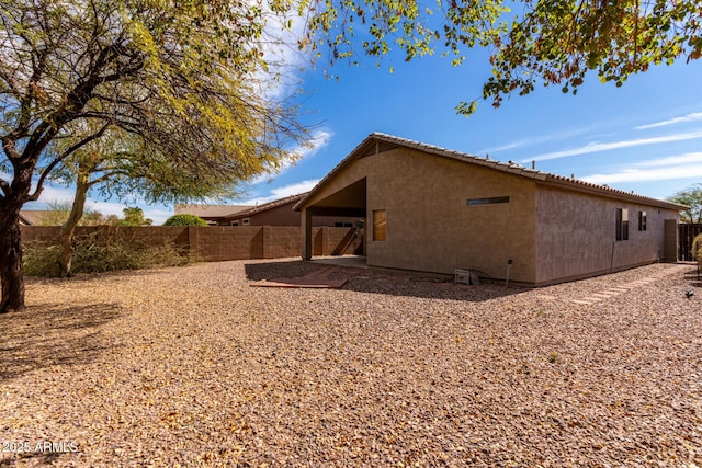 exterior space featuring a patio area, a fenced backyard, and stucco siding