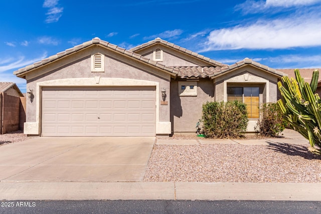 view of front of house with a tile roof, driveway, an attached garage, and stucco siding