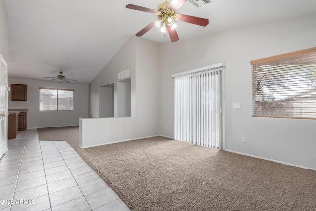 spare room featuring light tile patterned floors, visible vents, light colored carpet, lofted ceiling, and ceiling fan