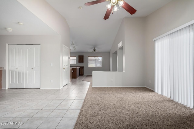 unfurnished living room with light carpet, light tile patterned floors, ceiling fan, and baseboards