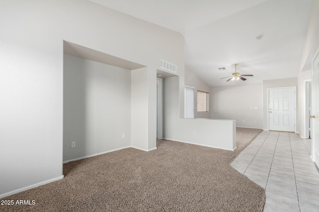 empty room featuring a ceiling fan, light colored carpet, visible vents, and vaulted ceiling