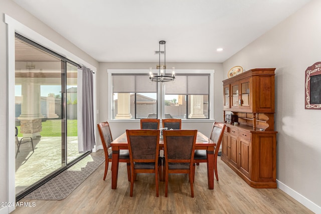 dining space featuring light hardwood / wood-style floors and an inviting chandelier