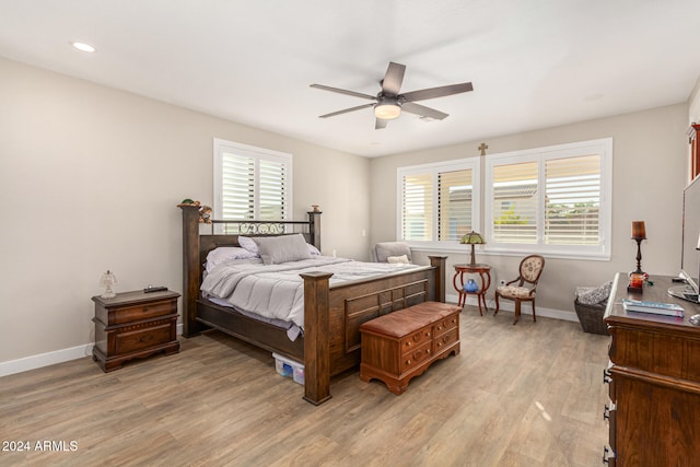 bedroom featuring ceiling fan, hardwood / wood-style flooring, and multiple windows