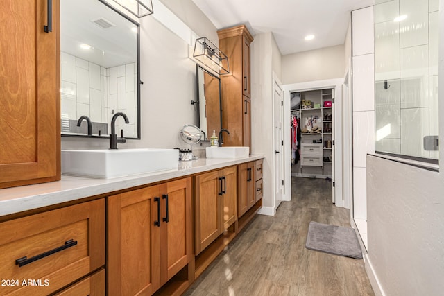 bathroom featuring vanity, wood-type flooring, and tiled shower