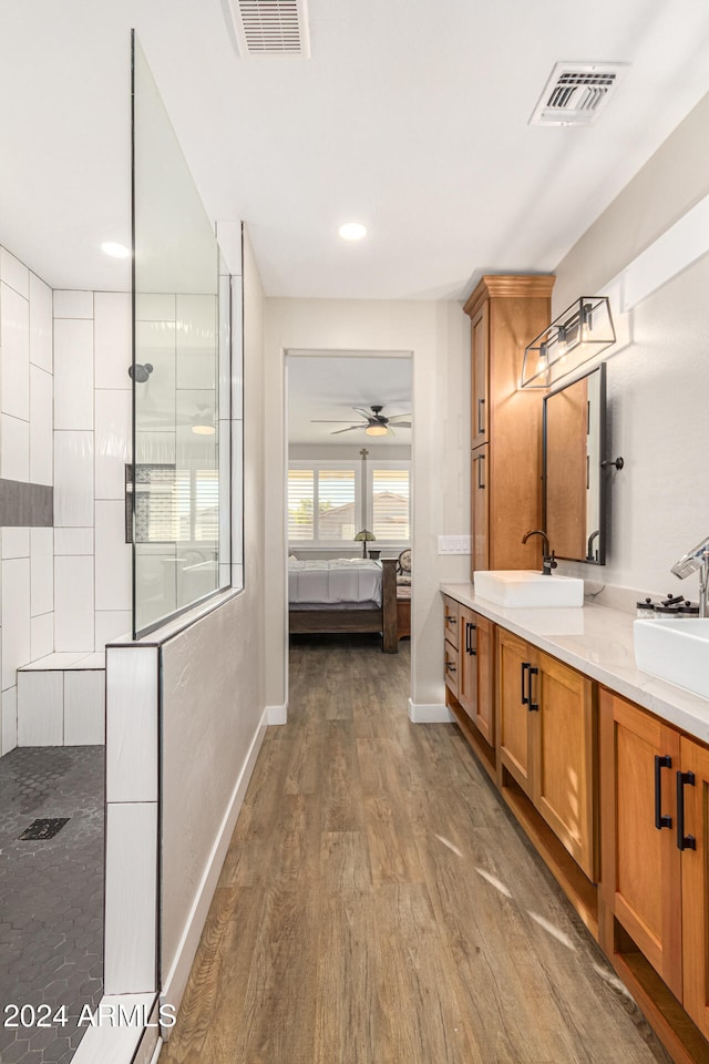 bathroom featuring vanity, hardwood / wood-style floors, walk in shower, and ceiling fan