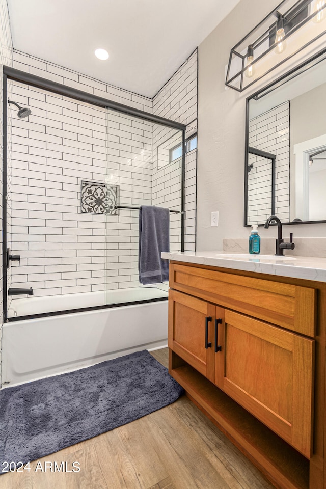 bathroom featuring vanity, enclosed tub / shower combo, and hardwood / wood-style flooring