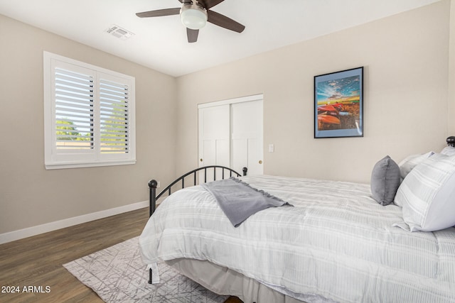 bedroom with dark hardwood / wood-style floors, a closet, and ceiling fan