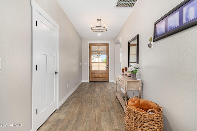 entryway with hardwood / wood-style floors and a chandelier