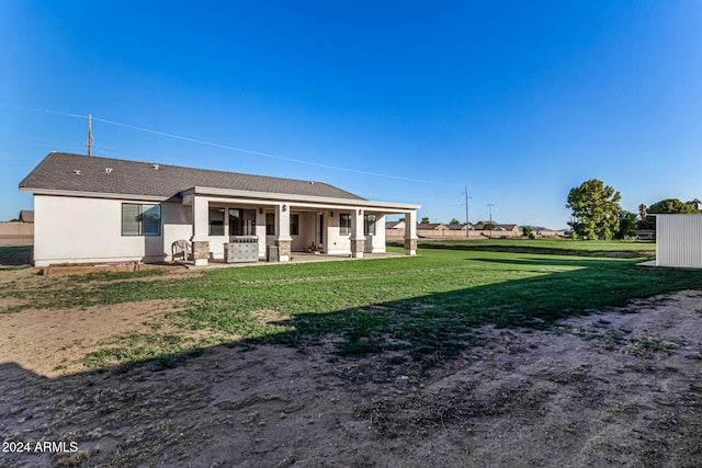 back of house with a yard and a patio