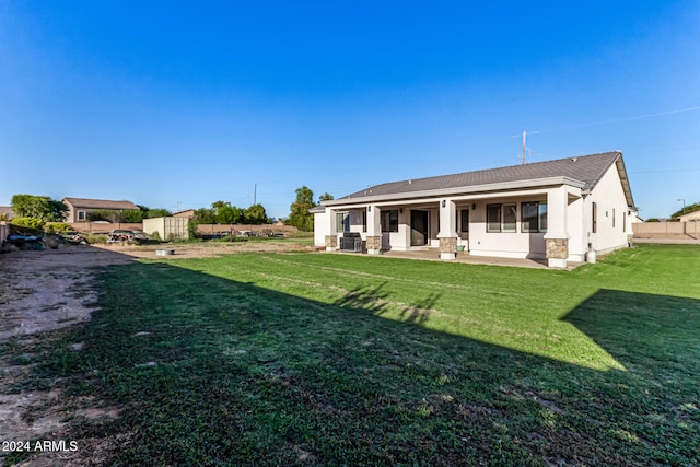 rear view of house featuring a lawn