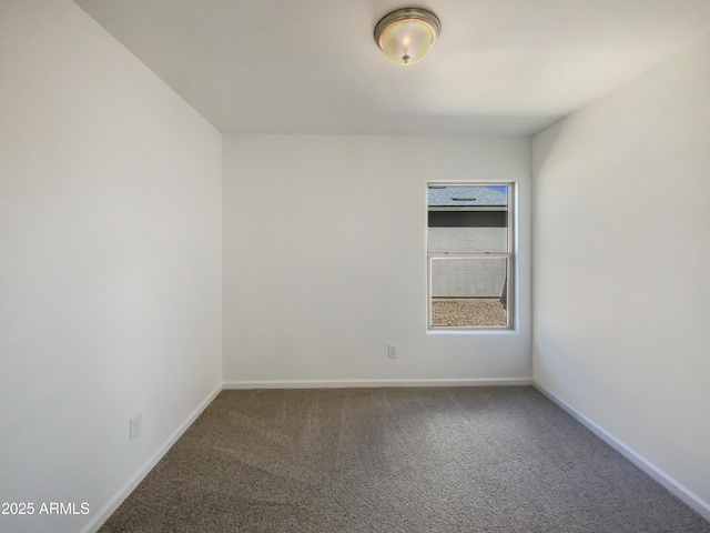 spare room with baseboards and carpet