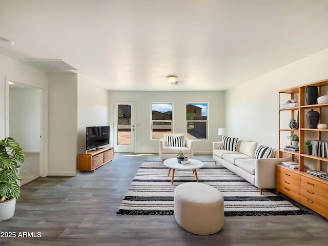living area featuring baseboards and wood finished floors