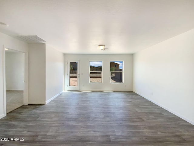unfurnished room featuring baseboards and wood finished floors
