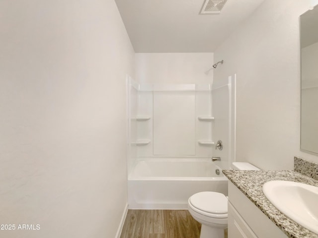 bathroom with visible vents, wood finished floors, vanity, toilet, and  shower combination