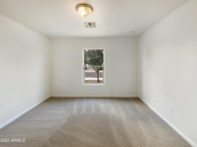 carpeted spare room featuring baseboards and visible vents