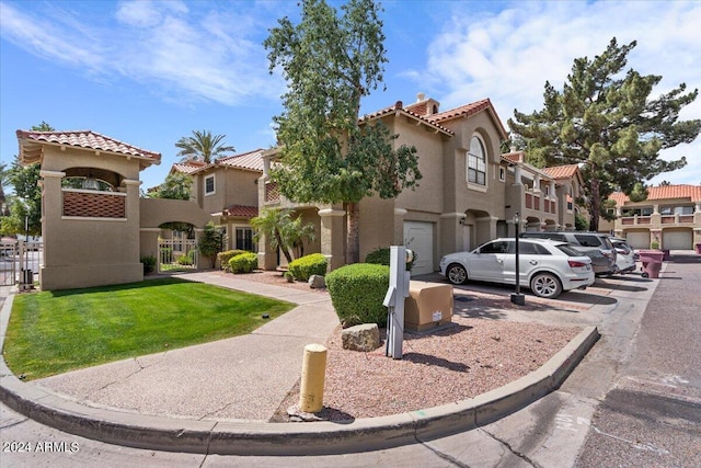 mediterranean / spanish house with a gate, a tile roof, a residential view, and stucco siding