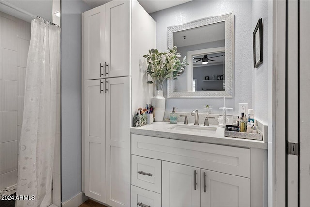 bathroom featuring a shower with curtain, a textured wall, vanity, and ceiling fan