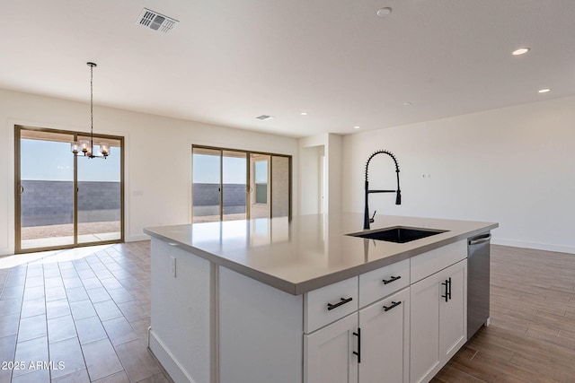 kitchen with dishwasher, sink, hanging light fixtures, an island with sink, and white cabinets