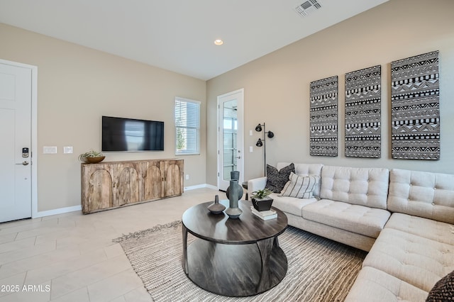 living area featuring baseboards and recessed lighting