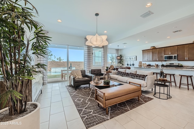 living area with recessed lighting and light tile patterned floors