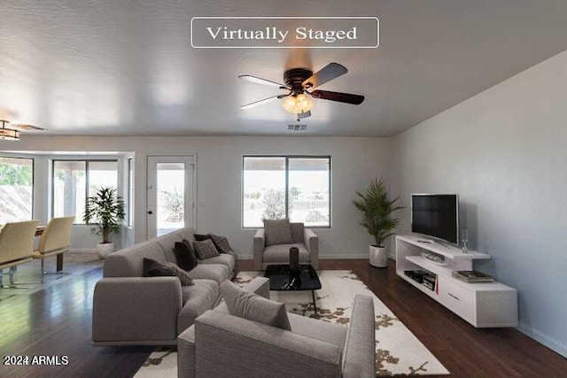 living room featuring ceiling fan and dark wood-type flooring