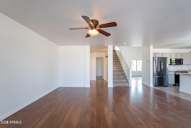 unfurnished living room with ceiling fan and dark hardwood / wood-style floors