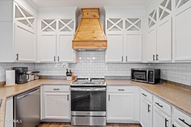 kitchen with white cabinetry, tasteful backsplash, stainless steel appliances, and custom range hood