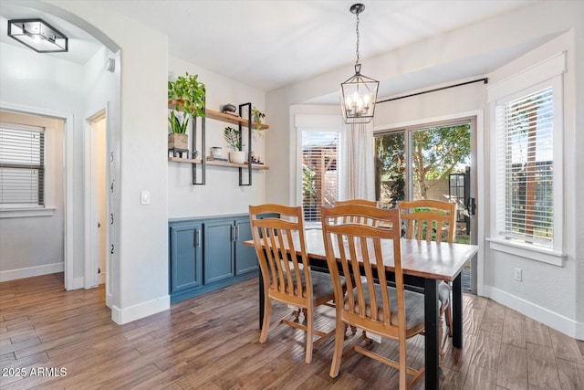 dining room featuring wood-type flooring and a chandelier