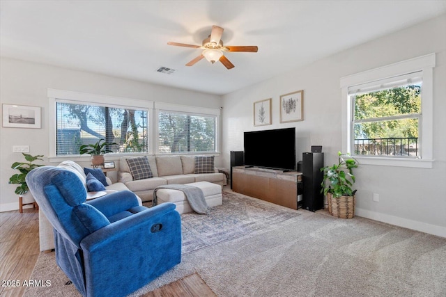 living room featuring a healthy amount of sunlight, ceiling fan, and light hardwood / wood-style flooring