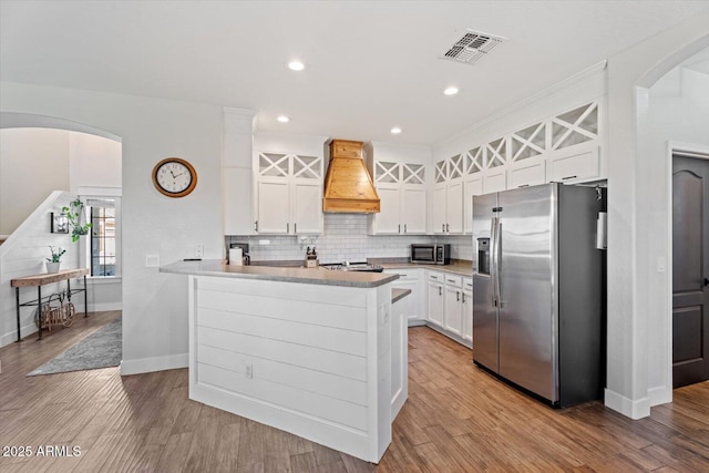 kitchen with premium range hood, white cabinetry, tasteful backsplash, kitchen peninsula, and stainless steel appliances