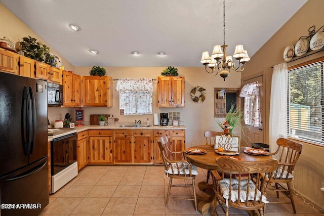 kitchen with sink, pendant lighting, lofted ceiling, light tile patterned flooring, and black appliances