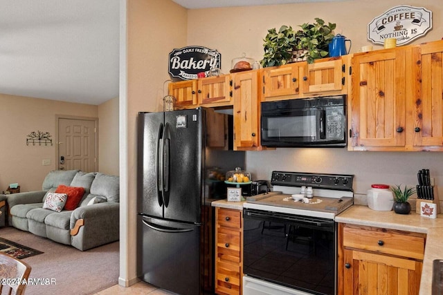 kitchen featuring black appliances and light carpet