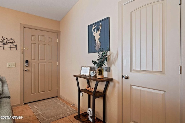 tiled foyer with a textured ceiling