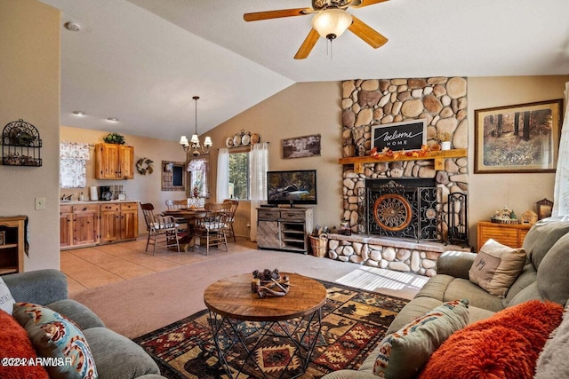 tiled living room with ceiling fan with notable chandelier, a stone fireplace, and lofted ceiling