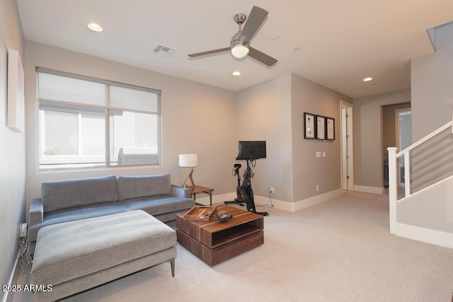 living room featuring ceiling fan, light colored carpet, visible vents, stairway, and recessed lighting