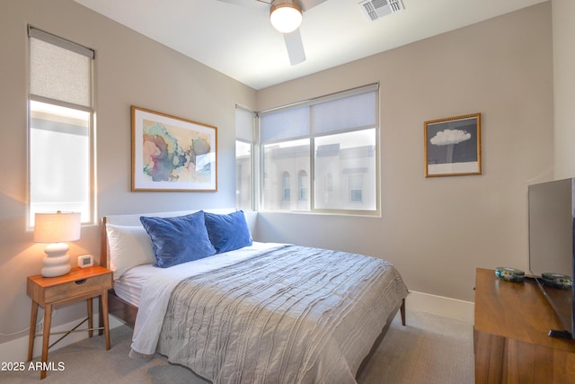 bedroom featuring carpet floors, multiple windows, baseboards, and visible vents