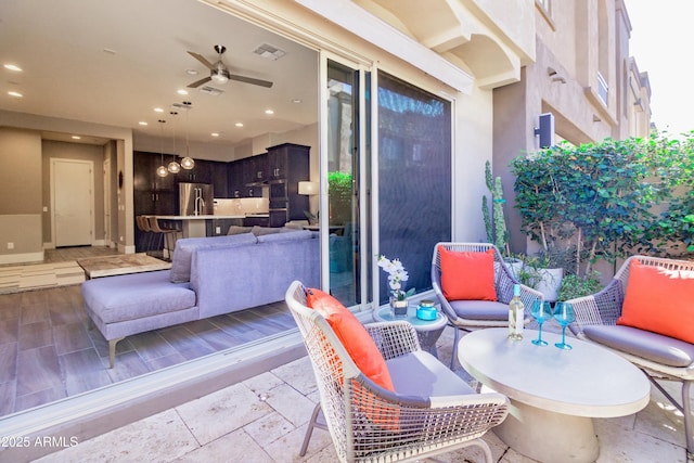 exterior space with outdoor lounge area, a ceiling fan, and visible vents