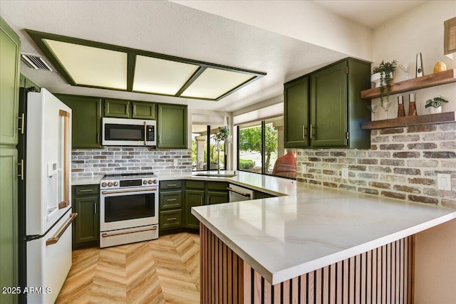 19025 N 96th Ave, Peoria, AZ 85382 - kitchen with green cabinets, appliances with stainless steel finishes, a peninsula, open shelves, and decorative backsplash