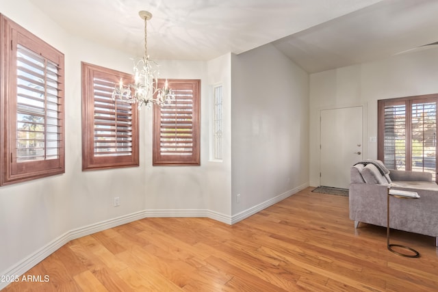 unfurnished dining area featuring light hardwood / wood-style floors and a notable chandelier