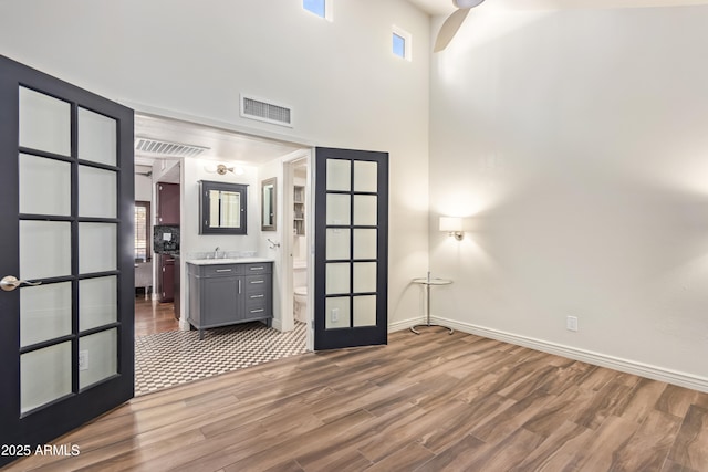 interior space with sink, hardwood / wood-style flooring, connected bathroom, and french doors