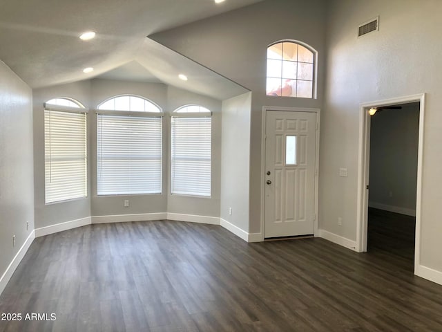 entryway with dark wood-style floors, vaulted ceiling, a wealth of natural light, and baseboards