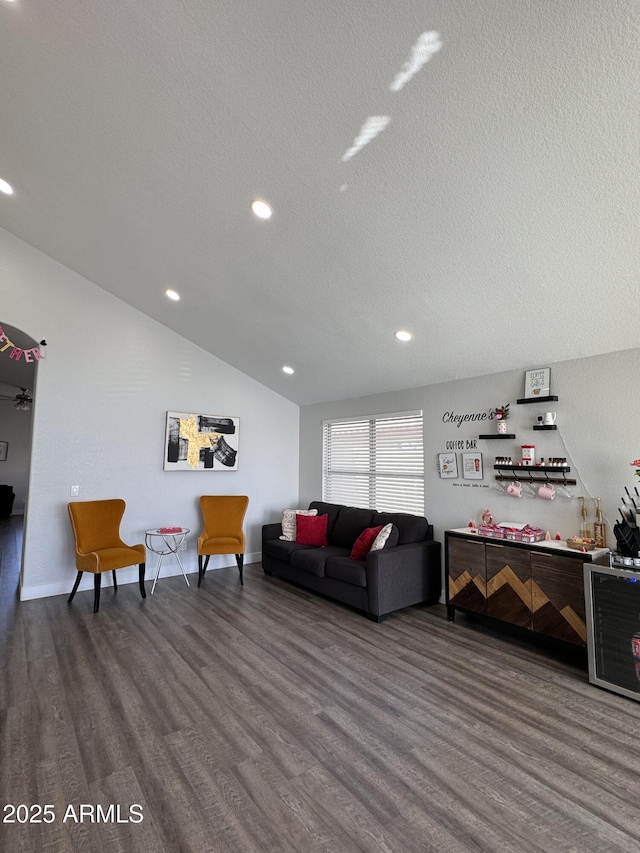 living room featuring lofted ceiling, recessed lighting, a textured ceiling, wood finished floors, and baseboards