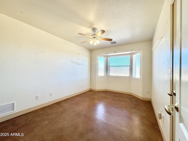 unfurnished room featuring visible vents, a textured ceiling, concrete floors, and baseboards