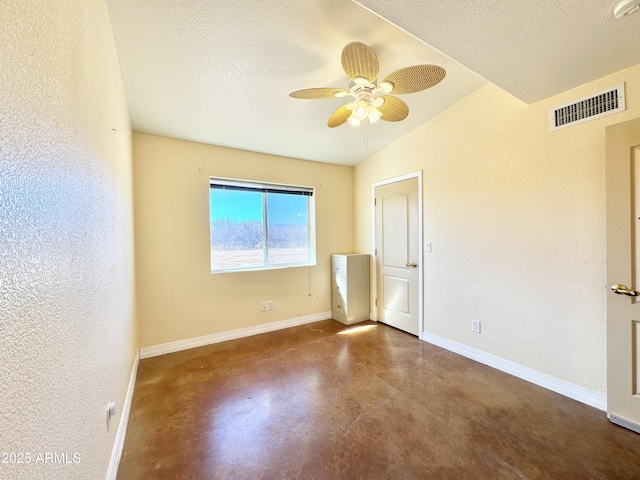 empty room with baseboards, visible vents, concrete flooring, and a textured ceiling