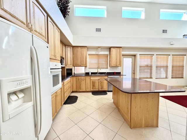 kitchen with dark countertops, light tile patterned flooring, visible vents, and stainless steel appliances