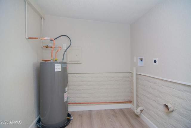 utility room featuring electric panel and water heater