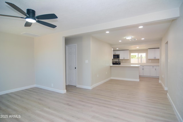 unfurnished living room featuring light wood-style floors, recessed lighting, and baseboards