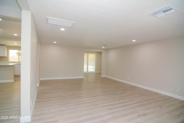 empty room with baseboards, recessed lighting, visible vents, and light wood-style floors