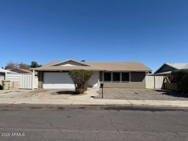 ranch-style house with a garage, stucco siding, driveway, and fence