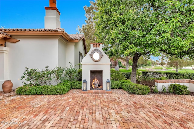 view of patio / terrace with a warm lit fireplace